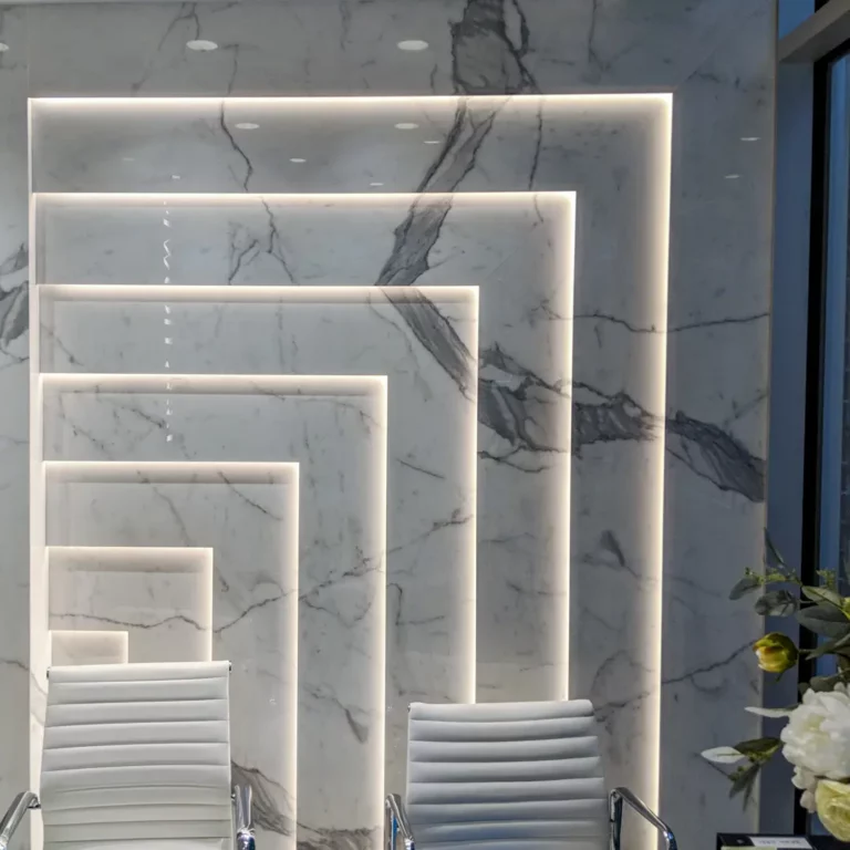 Custom LED architectural lighting on marble panels creating glowing recessed frames indoors