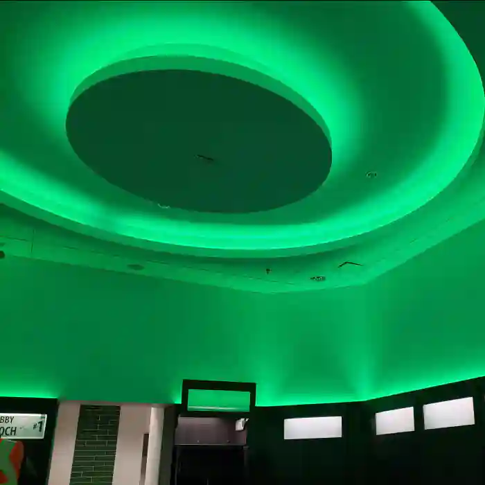 Green LED cove lighting in circular ceiling design glowing vibrant emerald in modern interior