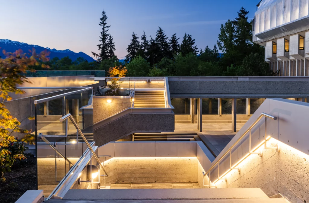 Modern campus stairs at SFU Academic Quadrangle with integrated LED step lighting at dusk and mountain views