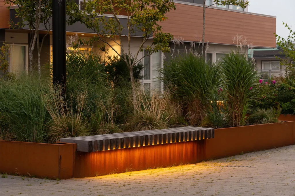 Architectural area lighting with warm LED bench and planter illumination in modern outdoor commercial landscape Canada